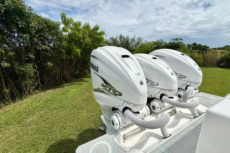  Yacht Photos Pics Triple Yamaha outboard engines on a 2023 Contender 39 Fisharound boat, parked on grass.