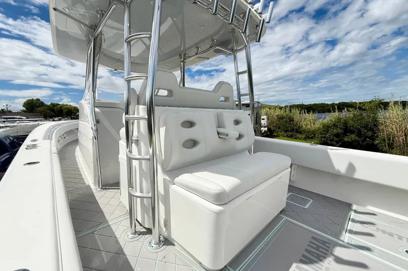  Yacht Photos Pics 2023 Contender 39 Fisharound boat with white seating and stainless steel ladder under a blue sky.