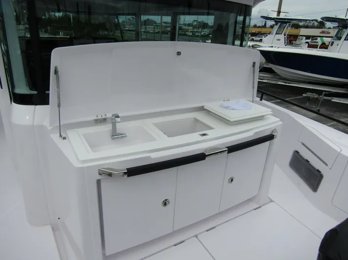  Yacht Photos Pics 2024 Axopar 37XC CROSS CABIN boat with outdoor sink and storage area.