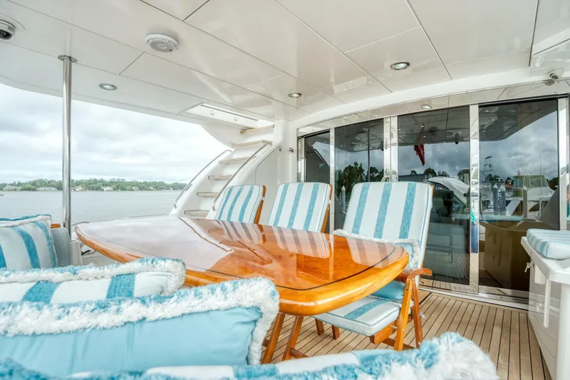 Majestik Yacht Photos Pics Luxurious 2007 Hatteras 80 Enclosed Bridge yacht with elegant outdoor seating and dining area.