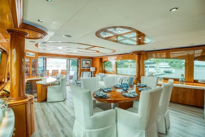 Majestik Yacht Photos Pics Luxurious interior of 2007 Hatteras 80 Enclosed Bridge yacht with elegant dining area and large windows.