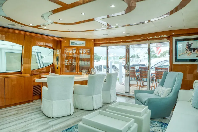 Majestik Yacht Photos Pics Luxurious interior of 2007 Hatteras 80 Enclosed Bridge yacht with elegant seating and wood finishes.