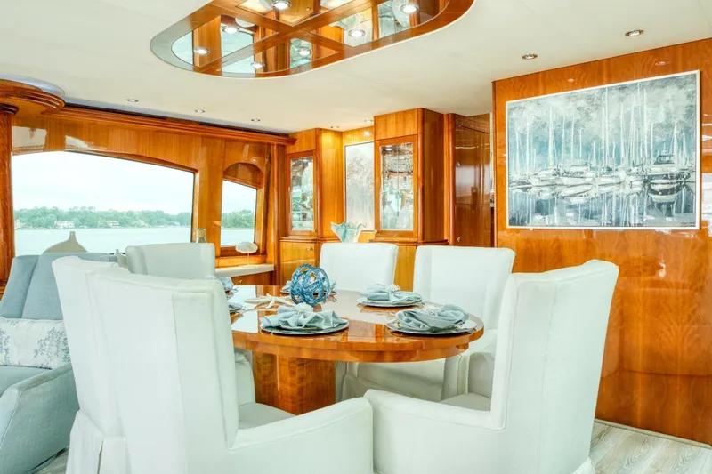 Majestik Yacht Photos Pics Luxurious dining area on 2007 Hatteras 80 Enclosed Bridge yacht with elegant wood finishes.