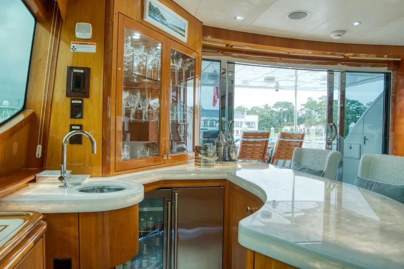 Majestik Yacht Photos Pics Luxurious interior of 2007 Hatteras 80 Enclosed Bridge yacht with bar and seating area.
