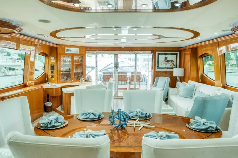 Majestik Yacht Photos Pics Luxurious interior of 2007 Hatteras 80 Enclosed Bridge yacht with elegant dining setup.
