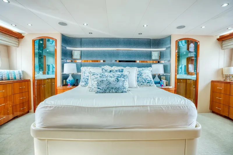 Majestik Yacht Photos Pics Luxurious bedroom interior on 2007 Hatteras 80 Enclosed Bridge yacht, featuring elegant wood accents.