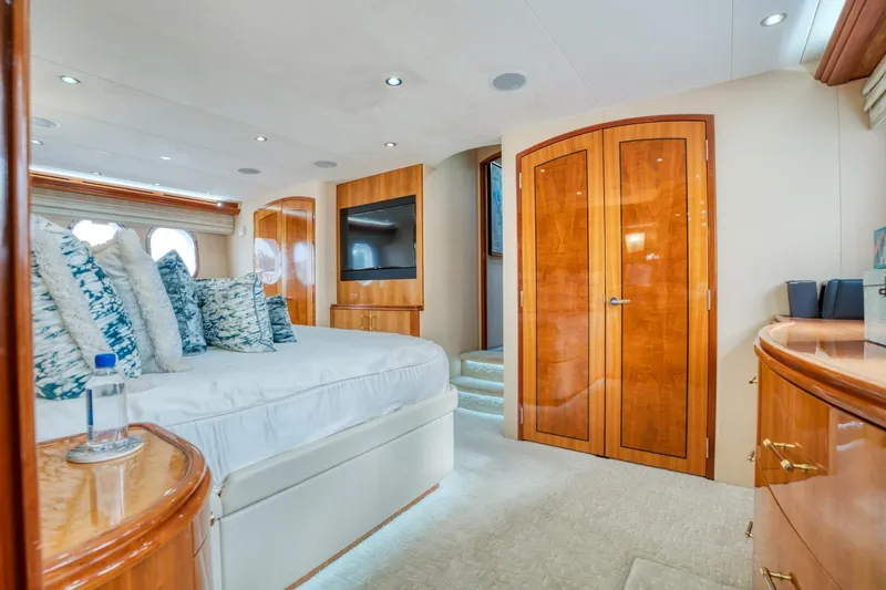 Majestik Yacht Photos Pics Luxurious bedroom interior of 2007 Hatteras 80 Enclosed Bridge yacht with elegant wood finishes.