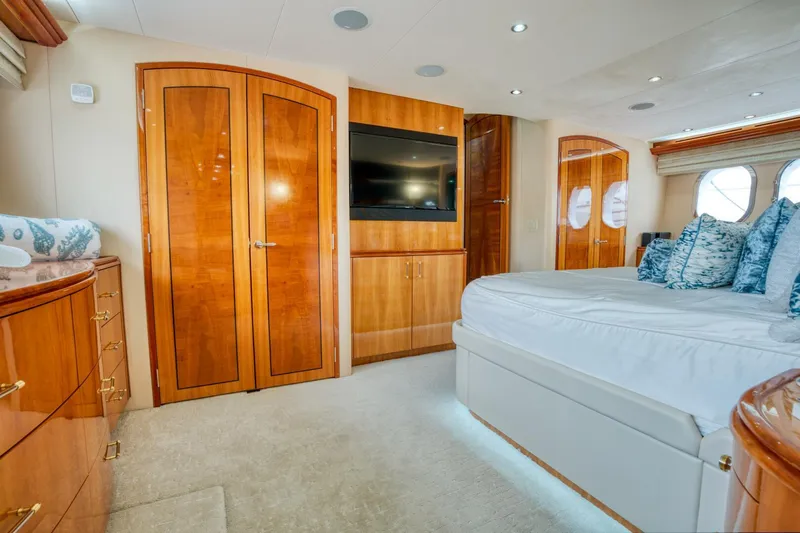 Majestik Yacht Photos Pics Luxurious bedroom interior of 2007 Hatteras 80 Enclosed Bridge yacht with elegant wood finishes.