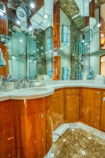 Majestik Yacht Photos Pics Luxurious bathroom on 2007 Hatteras 80 Enclosed Bridge yacht with wood cabinetry and mirrored walls.