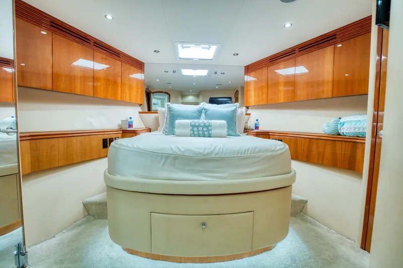 Majestik Yacht Photos Pics Luxurious bedroom interior of 2007 Hatteras 80 Enclosed Bridge yacht with elegant wood finishes.