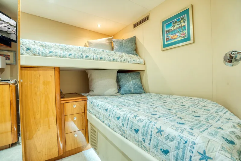 Majestik Yacht Photos Pics Bunk beds in 2007 Hatteras 80 Enclosed Bridge yacht cabin, featuring nautical-themed bedding.
