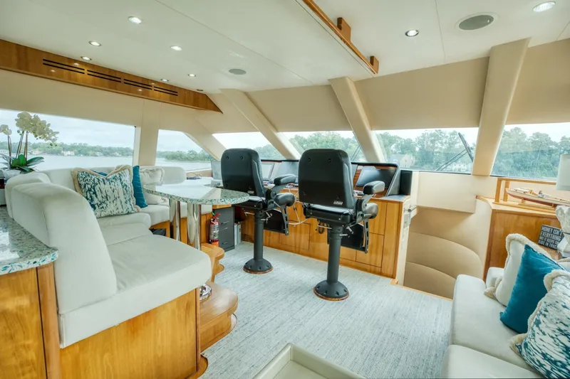 Majestik Yacht Photos Pics Luxurious interior of 2007 Hatteras 80 Enclosed Bridge yacht with plush seating and helm.