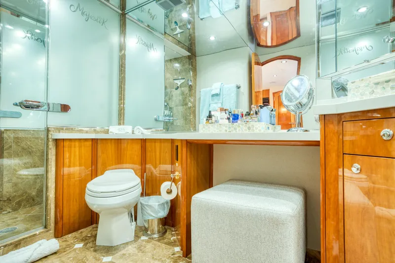 Majestik Yacht Photos Pics Luxurious bathroom in 2007 Hatteras 80 Enclosed Bridge yacht with elegant wood cabinetry and marble flooring.