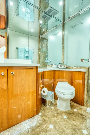 Majestik Yacht Photos Pics Luxurious bathroom in 2007 Hatteras 80 Enclosed Bridge yacht with wood cabinetry and marble flooring.