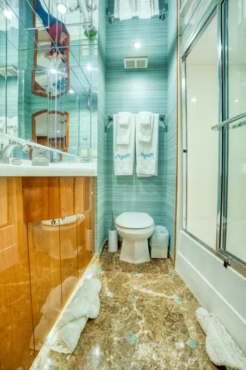 Majestik Yacht Photos Pics Luxurious bathroom on 2007 Hatteras 80 Enclosed Bridge yacht with marble flooring and modern fixtures.