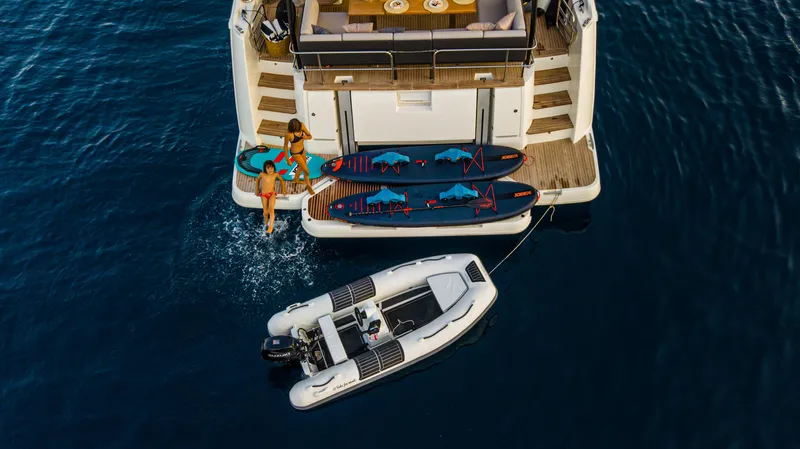  Yacht Photos Pics 2024 Prestige M48 yacht with paddleboards and dinghy on calm water.