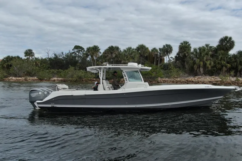 Destroyer Yacht Photos Pics 2018 HCB 39 Speciale boat cruising near a lush, tropical shoreline.