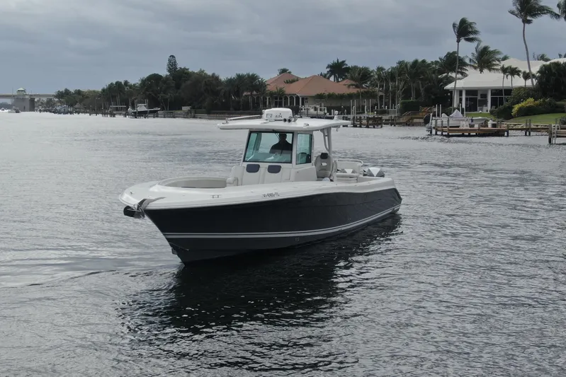 Destroyer Yacht Photos Pics 2018 HCB 39 Speciale boat cruising on a calm waterway with palm trees in the background.
