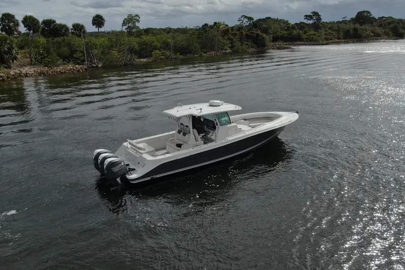 Destroyer Yacht Photos Pics 2018 HCB 39 Speciale boat cruising on a calm river with lush greenery.