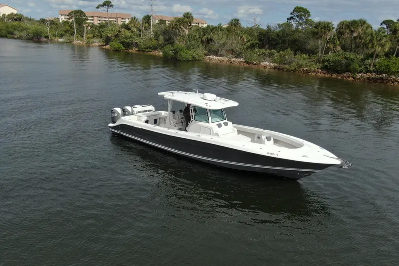 Destroyer Yacht Photos Pics 2018 HCB 39 Speciale boat cruising on a calm river with lush greenery.