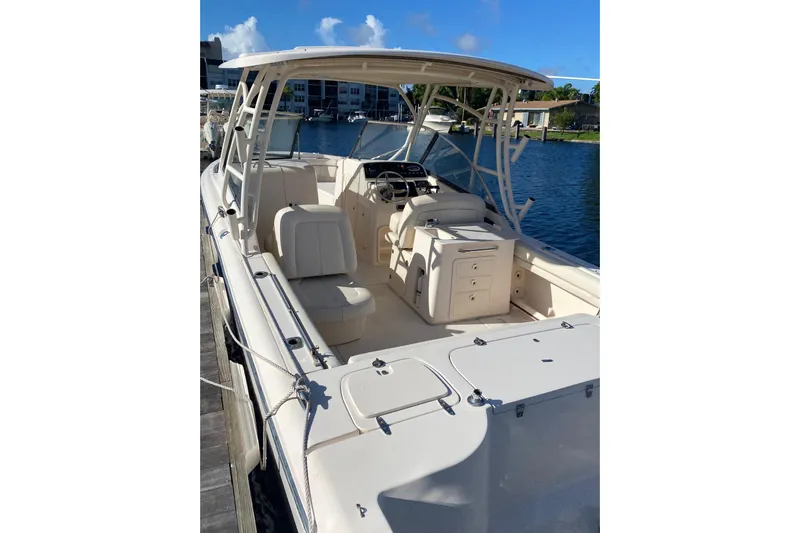  Yacht Photos Pics 2015 Grady-White Freedom 285 boat docked by the water, showcasing spacious seating and helm.