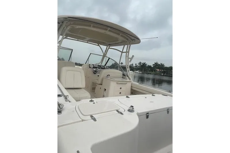  Yacht Photos Pics 2015 Grady-White Freedom 285 boat interior with seating and helm, on a calm waterway.