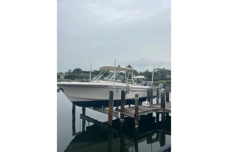  Yacht Photos Pics 2015 Grady-White Freedom 285 boat docked on a calm waterfront.