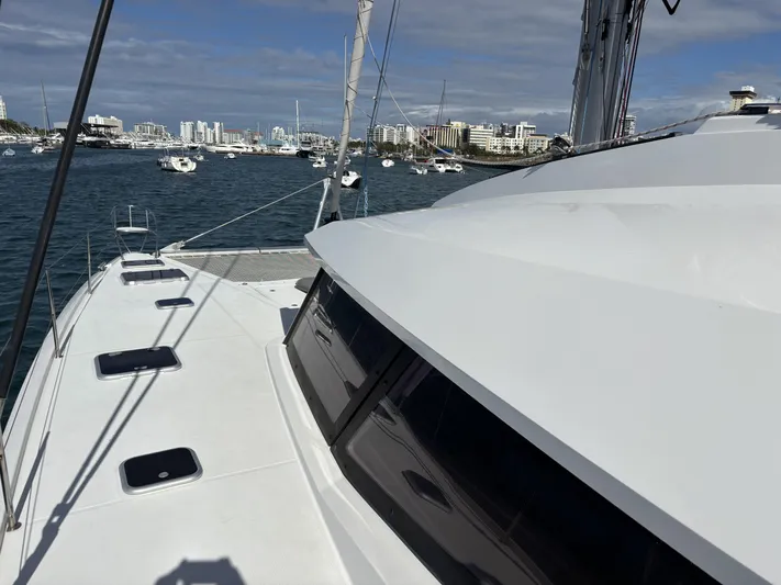 Adventure For Seven Yacht Photos Pics 2017 Fountaine Pajot Ipanema 58 catamaran on water, city skyline in background.