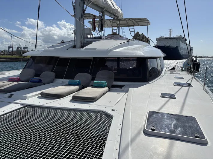 Adventure For Seven Yacht Photos Pics 2017 Fountaine Pajot Ipanema 58 catamaran with sun loungers on deck, docked in a marina.