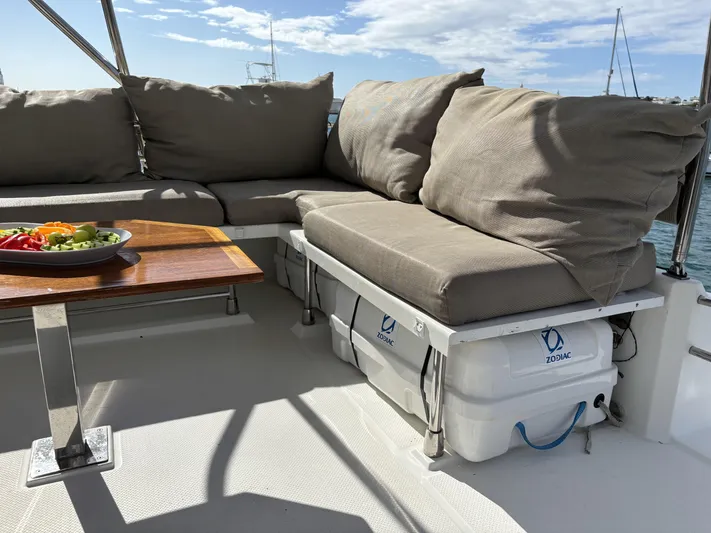 Adventure For Seven Yacht Photos Pics Luxurious seating area on 2017 Fountaine Pajot Ipanema 58 yacht with cushions and table.