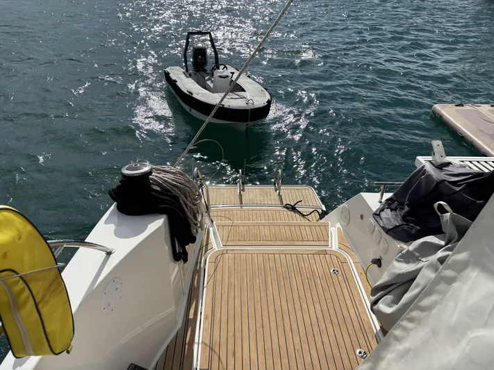 Adventure For Seven Yacht Photos Pics 2017 Fountaine Pajot Ipanema 58 yacht with wooden deck and small boat nearby.