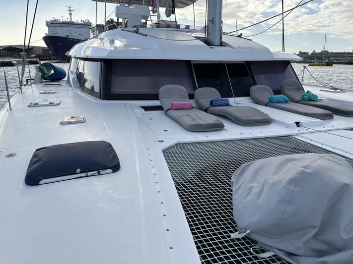Adventure For Seven Yacht Photos Pics 2017 Fountaine Pajot Ipanema 58 catamaran with sun loungers on deck, docked in a marina.