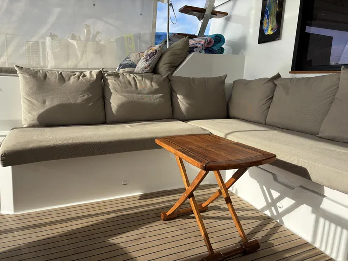 Adventure For Seven Yacht Photos Pics Cozy seating area on 2017 Fountaine Pajot Ipanema 58 yacht with wooden table.