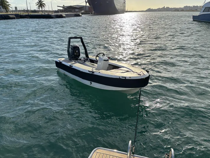 Adventure For Seven Yacht Photos Pics Small motorboat docked near a Fountaine Pajot Ipanema 58, 2017, in a sunny harbor.