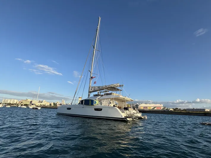 Adventure For Seven Yacht Photos Pics 2017 Fountaine Pajot Ipanema 58 catamaran sailing on calm waters under a clear blue sky.