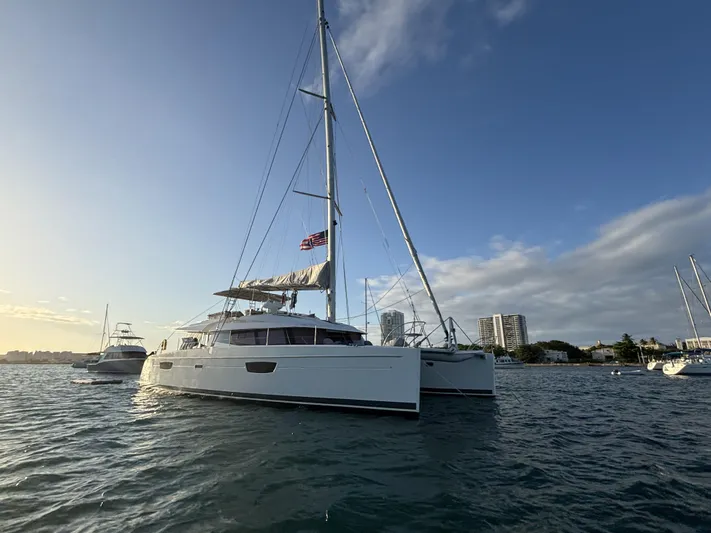 Adventure For Seven Yacht Photos Pics 2017 Fountaine Pajot Ipanema 58 catamaran sailing on calm waters at sunset.