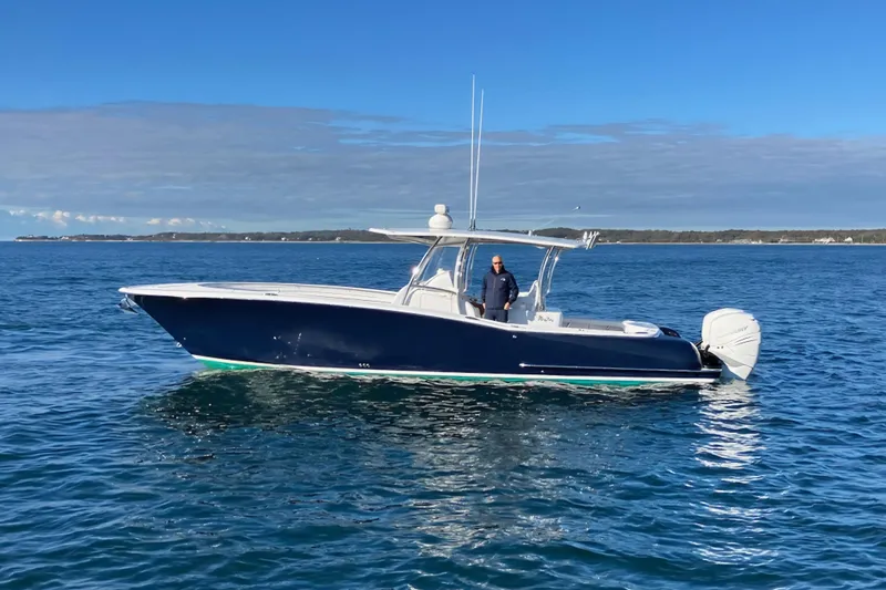 Sugar Mags Yacht Photos Pics 2022 Mag Bay 33 CC boat on calm ocean waters under clear blue sky.