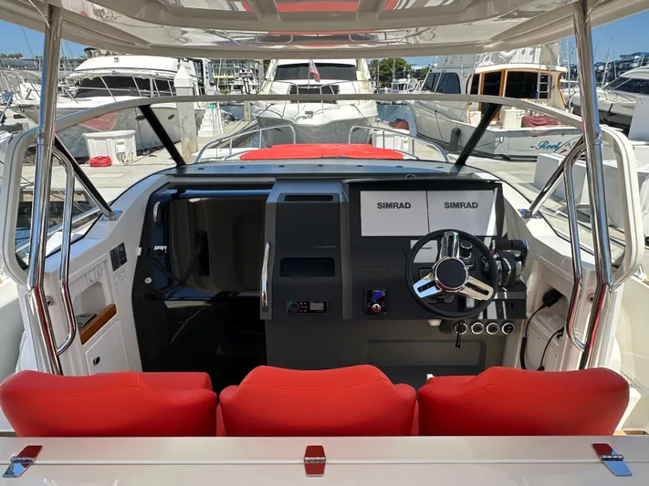 Mdr Yacht Photos Pics Interior cockpit of 2021 Nimbus T11 boat with red seats and Simrad navigation system.