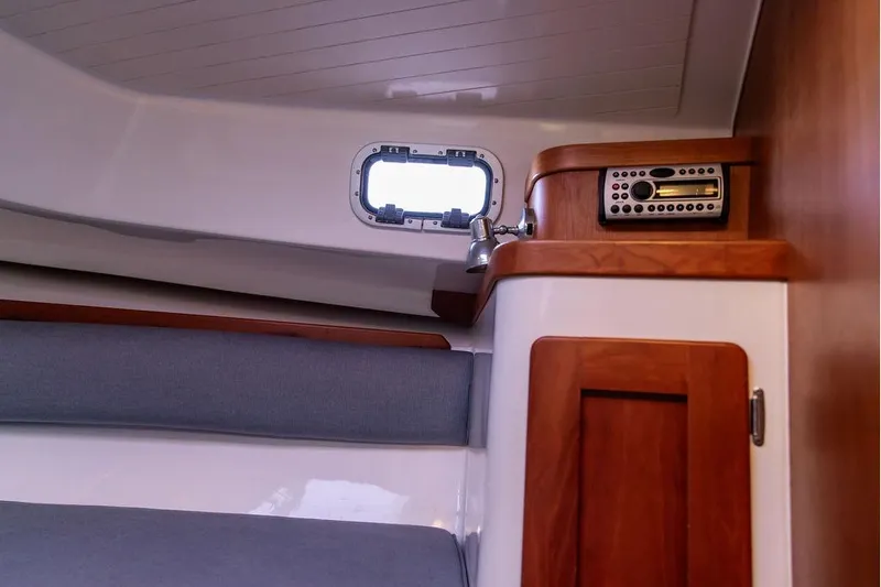 Battendown Yacht Photos Pics Interior of 2007 Hunt Surfhunter 29 boat with wood accents and porthole window.