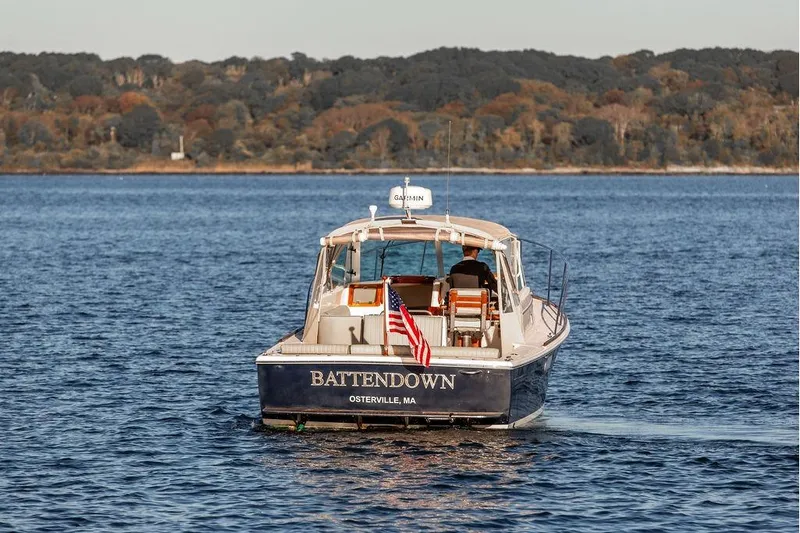 Battendown Yacht Photos Pics 2007 Hunt Surfhunter 29 boat cruising on a calm lake with forested shoreline.