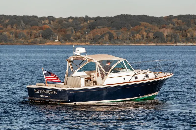 Battendown Yacht Photos Pics 2007 Hunt Surfhunter 29 boat on water, American flag, wooded shoreline background.