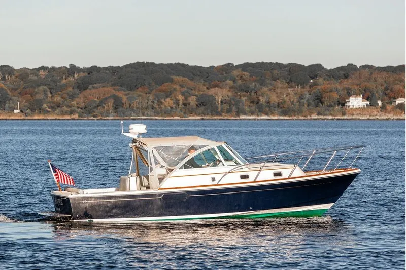 Battendown Yacht Photos Pics 2007 Hunt Surfhunter 29 boat cruising on a calm lake with scenic forest backdrop.