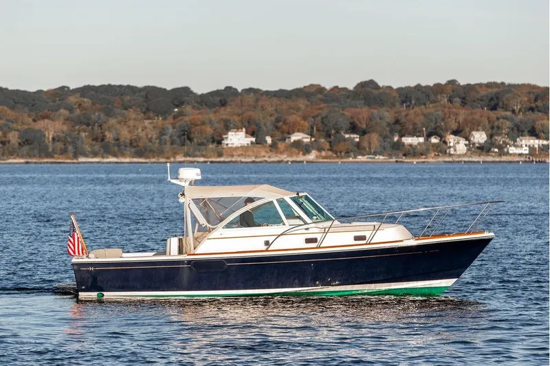 Battendown Yacht Photos Pics 2007 Hunt Surfhunter 29 boat cruising on a calm lake with scenic shoreline.
