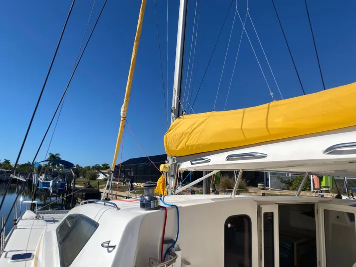 Sandy Pause Yacht Photos Pics 2003 Leopard 47 catamaran with yellow sail docked in harbor.