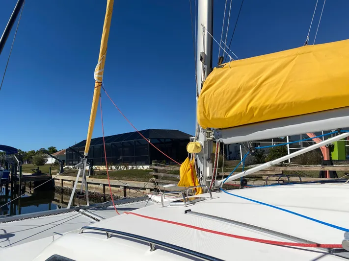 Sandy Pause Yacht Photos Pics 2003 Leopard 47 sailboat with yellow sail in harbor.