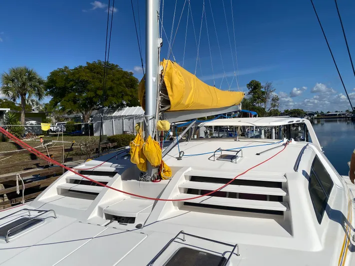 Sandy Pause Yacht Photos Pics 2003 Leopard 47 catamaran with yellow sail docked in harbor.