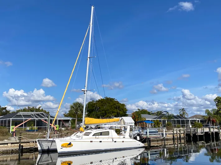 Sandy Pause Yacht Photos Pics 2003 Leopard 47 catamaran docked, clear blue sky.