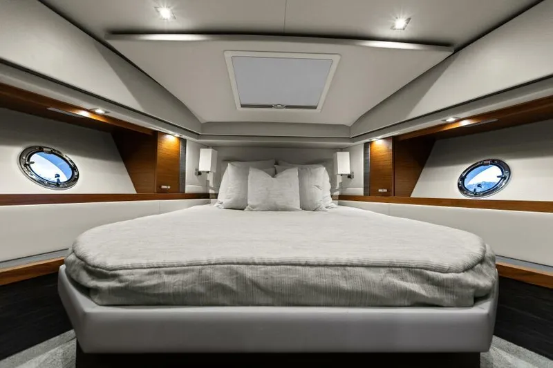 Big Eyes Yacht Photos Pics Luxurious bedroom interior of 2019 Tiara Yachts 39 Coupe with elegant design and porthole windows.