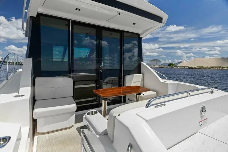 Big Eyes Yacht Photos Pics 2019 Tiara Yachts 39 Coupe, elegant deck with seating and table, scenic waterfront view.