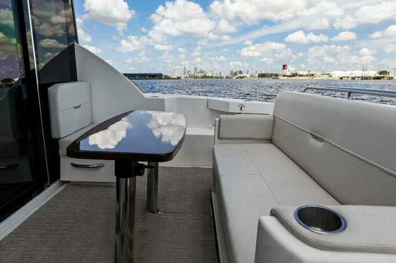 Big Eyes Yacht Photos Pics 2019 Tiara Yachts 39 Coupe deck with seating and table, overlooking water and skyline.